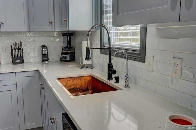 kitchen with decorative backsplash, sink, and gray cabinets