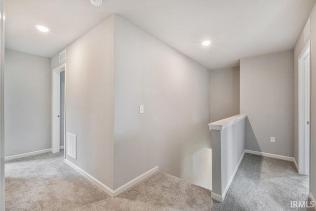 hallway featuring light colored carpet