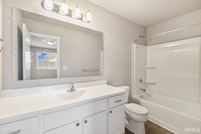 full bathroom with bathing tub / shower combination, hardwood / wood-style floors, vanity, and toilet