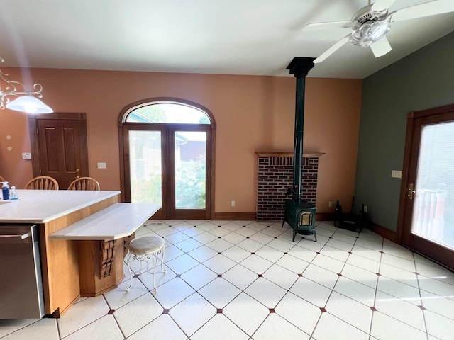 kitchen featuring ceiling fan, dishwasher, and a wood stove