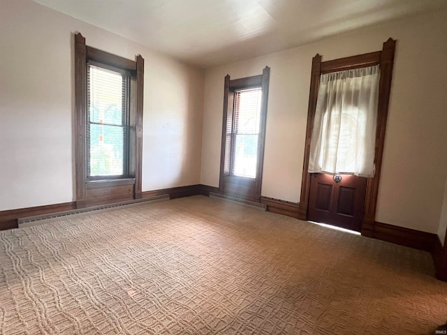 carpeted empty room with baseboard heating