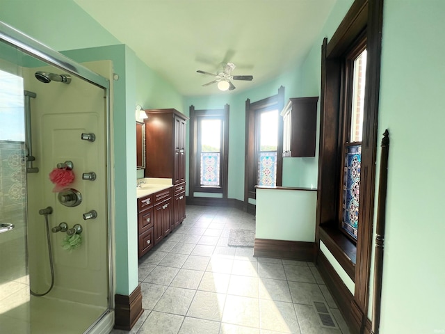 bathroom featuring vanity, walk in shower, ceiling fan, and tile patterned flooring