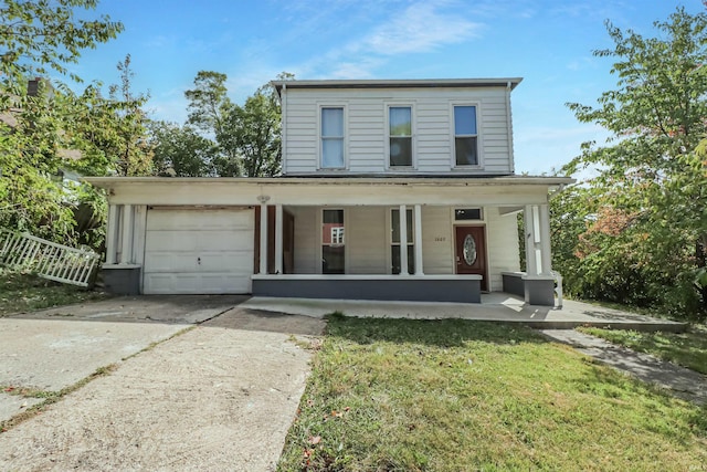 view of front of property featuring a front yard, covered porch, and a garage