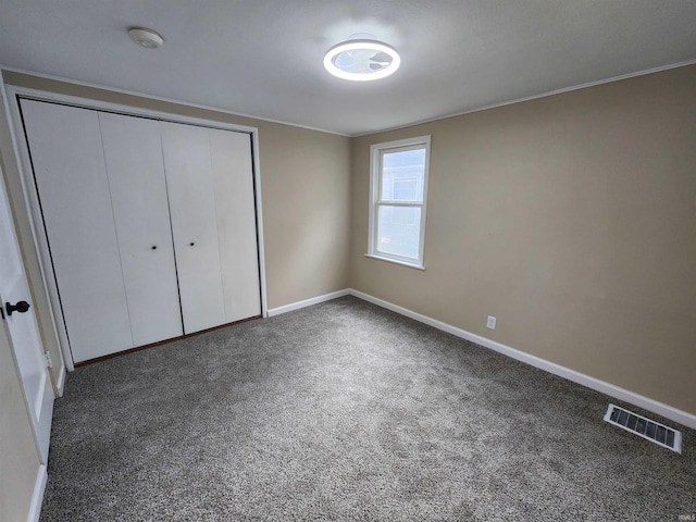 unfurnished bedroom featuring a closet and dark colored carpet