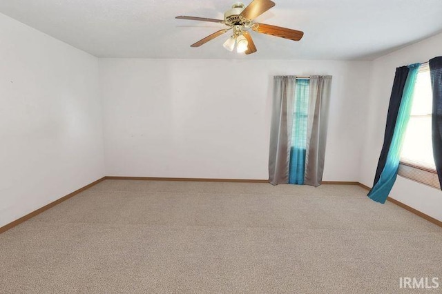 empty room featuring light colored carpet and ceiling fan