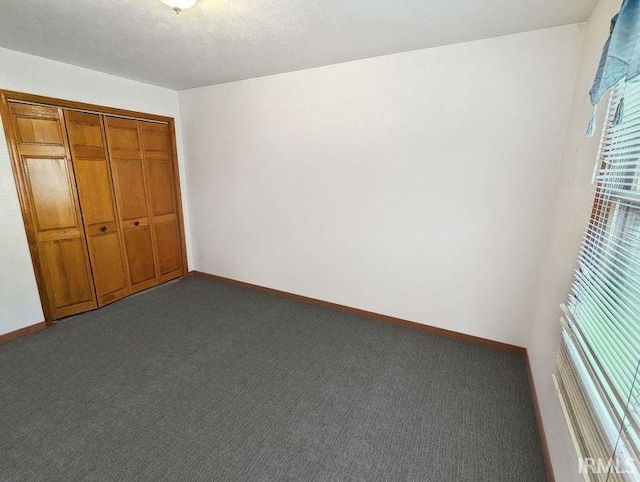 unfurnished bedroom featuring carpet, a textured ceiling, and a closet