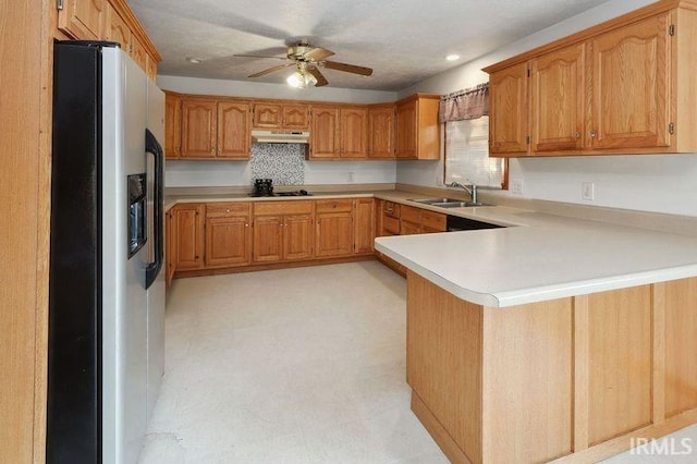 kitchen featuring black gas stovetop, sink, kitchen peninsula, ceiling fan, and stainless steel fridge with ice dispenser