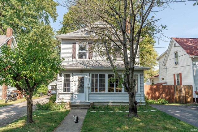 american foursquare style home with a front yard, driveway, fence, and entry steps