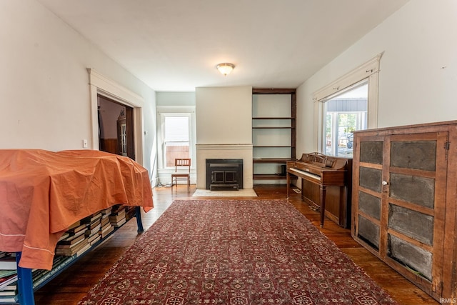 bedroom with a wood stove and dark hardwood / wood-style floors