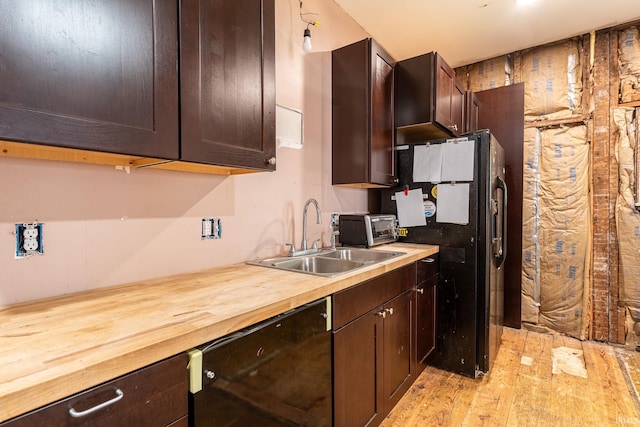 kitchen with wood counters, light wood-type flooring, sink, black appliances, and dark brown cabinets