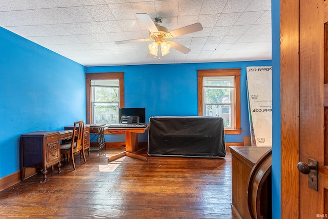 home office with ceiling fan and dark hardwood / wood-style flooring