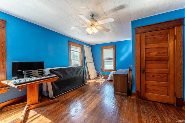 living room with dark wood-type flooring and ceiling fan