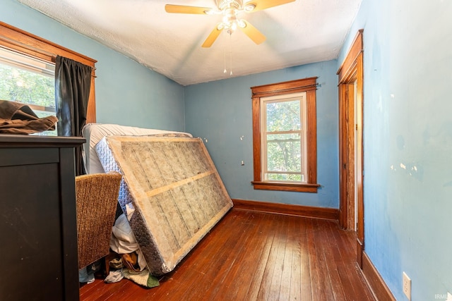 bedroom featuring a textured ceiling, ceiling fan, and dark hardwood / wood-style floors