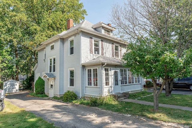 view of front of property featuring a shed