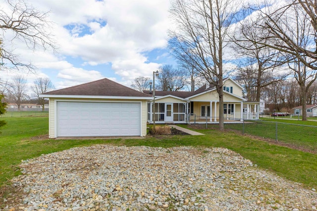 view of front of house featuring a garage, covered porch, and a front lawn