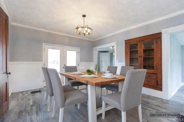 dining room with hardwood / wood-style floors, crown molding, and french doors