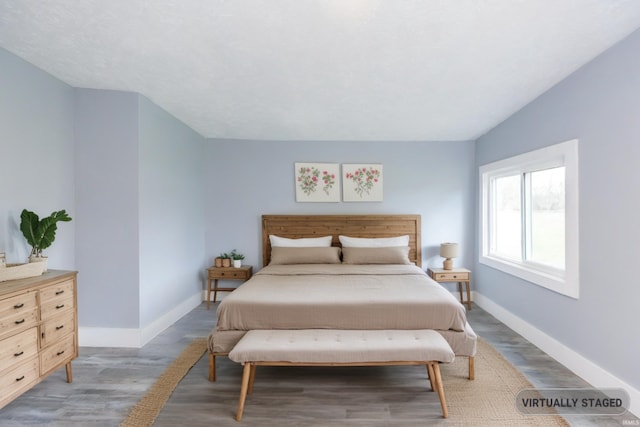 bedroom with lofted ceiling and hardwood / wood-style flooring