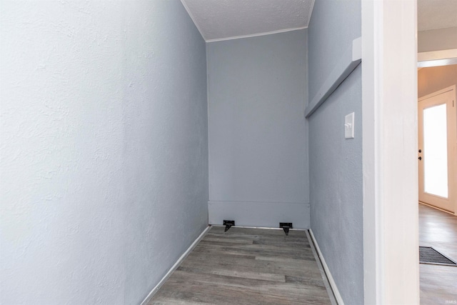 clothes washing area with wood-type flooring and a textured ceiling