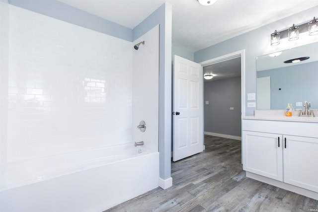 bathroom featuring hardwood / wood-style flooring, tiled shower / bath combo, and vanity