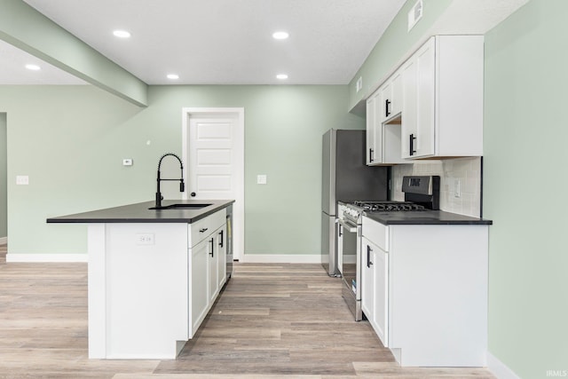 3615 Lindbergh Blvd, Fort Wayne, IN 46806 - kitchen featuring stainless steel gas range, dark countertops, a sink, a kitchen island with sink, and recessed lighting