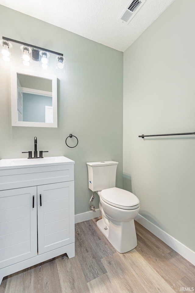 3615 Lindbergh Blvd, Fort Wayne, IN 46806 - bathroom with wood finished floors, baseboards, toilet, vanity, and a textured ceiling