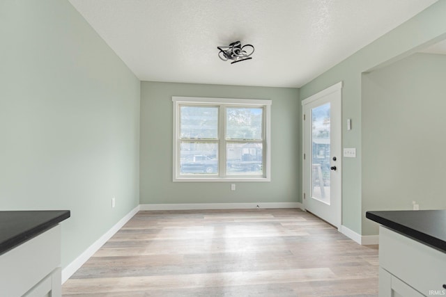 3615 Lindbergh Blvd, Fort Wayne, IN 46806 - unfurnished dining area with light wood finished floors, baseboards, and a textured ceiling