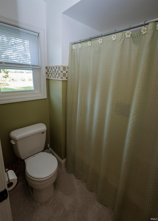 bathroom featuring a shower with curtain and toilet