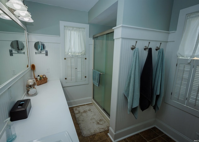 bathroom with an enclosed shower and tile patterned flooring