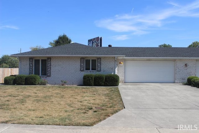 ranch-style house featuring a garage and a front lawn