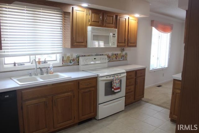 kitchen with crown molding, light tile patterned floors, white appliances, and sink