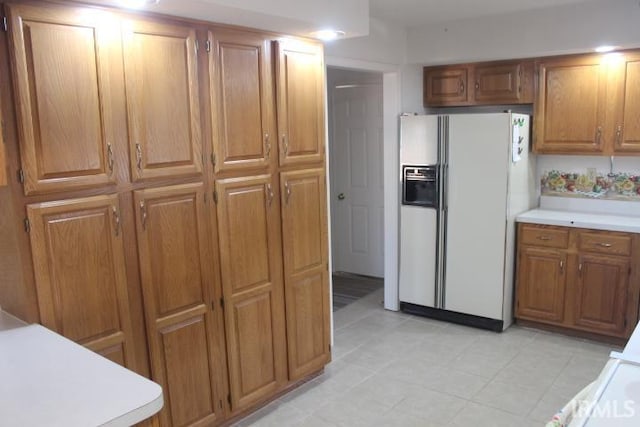 kitchen featuring white refrigerator with ice dispenser