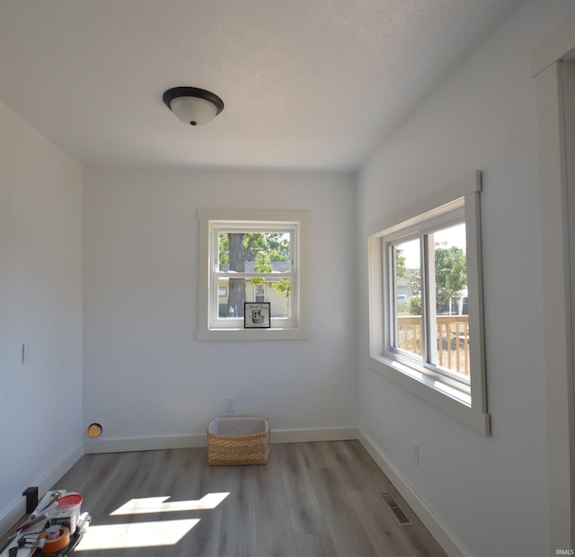 unfurnished room featuring a healthy amount of sunlight and hardwood / wood-style floors