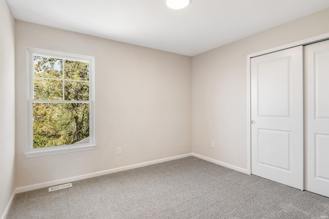 unfurnished bedroom with a closet and carpet flooring