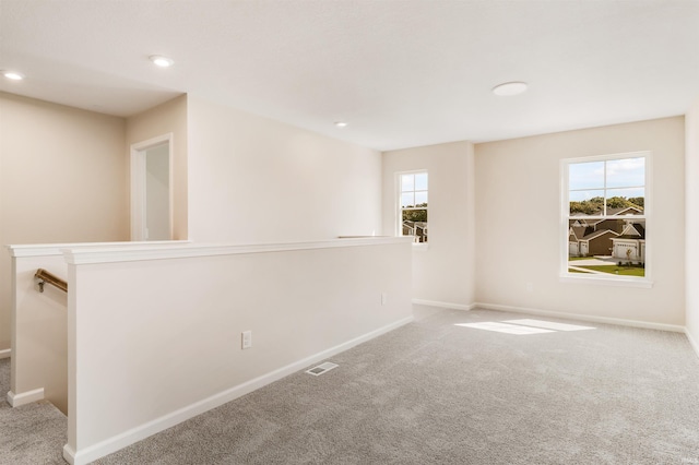 unfurnished room featuring light carpet