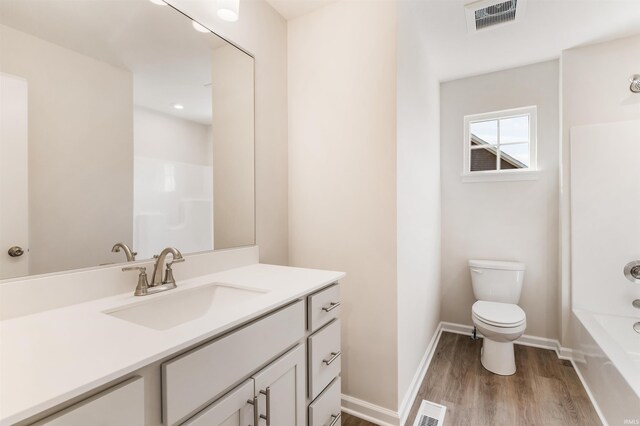 full bathroom with shower / bathtub combination, hardwood / wood-style floors, toilet, and vanity