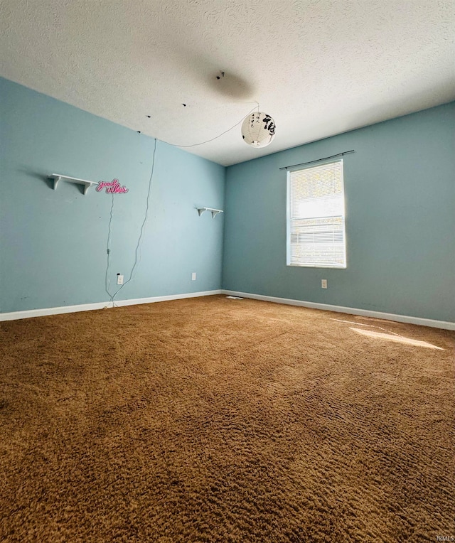 spare room with carpet and a textured ceiling