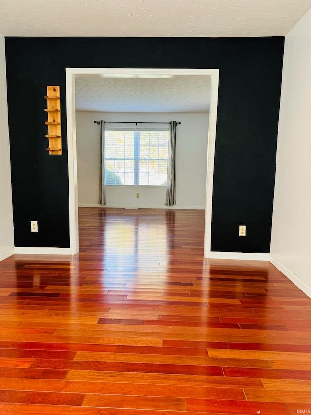 spare room featuring hardwood / wood-style floors and a textured ceiling