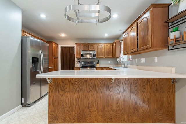 kitchen with kitchen peninsula, stainless steel appliances, and sink