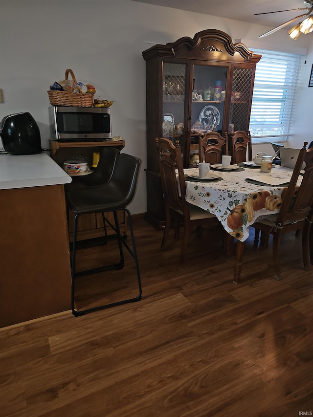 dining area with ceiling fan and dark hardwood / wood-style floors