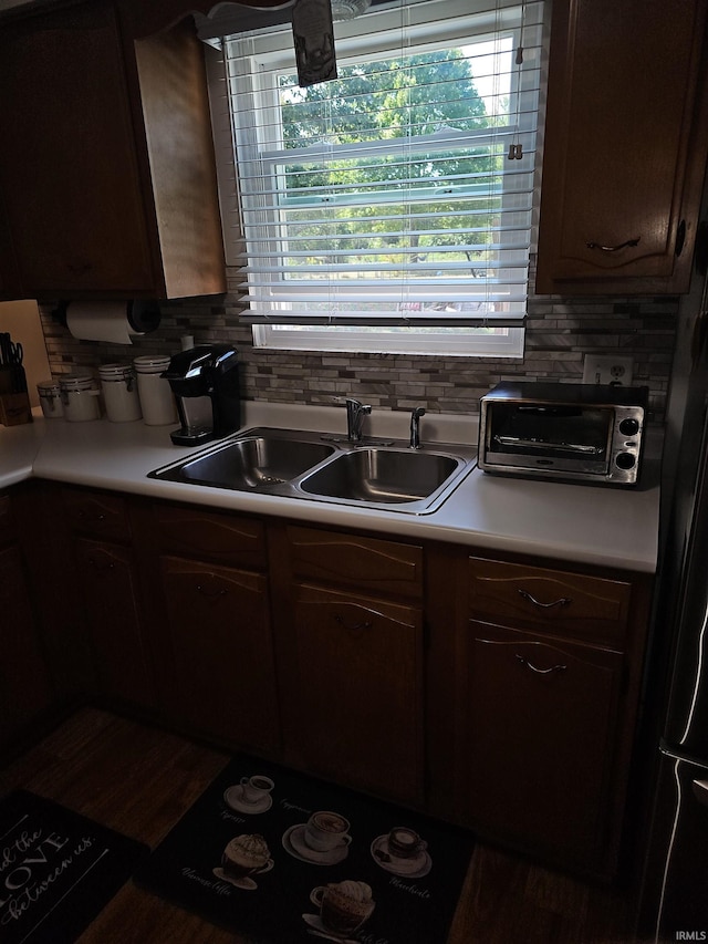 kitchen featuring dark brown cabinets, tasteful backsplash, and sink