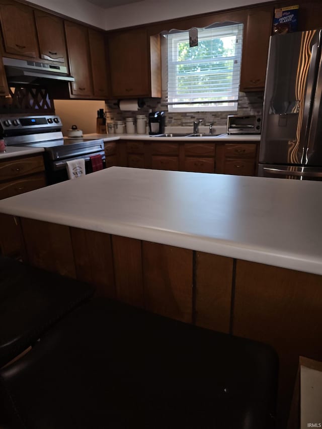 kitchen featuring exhaust hood, backsplash, stainless steel appliances, and sink