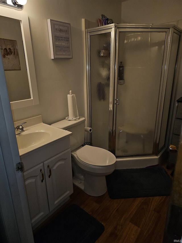 bathroom with vanity, toilet, hardwood / wood-style floors, and walk in shower