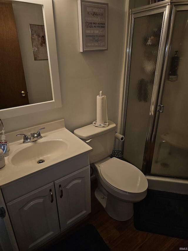 bathroom featuring vanity, toilet, an enclosed shower, and hardwood / wood-style floors