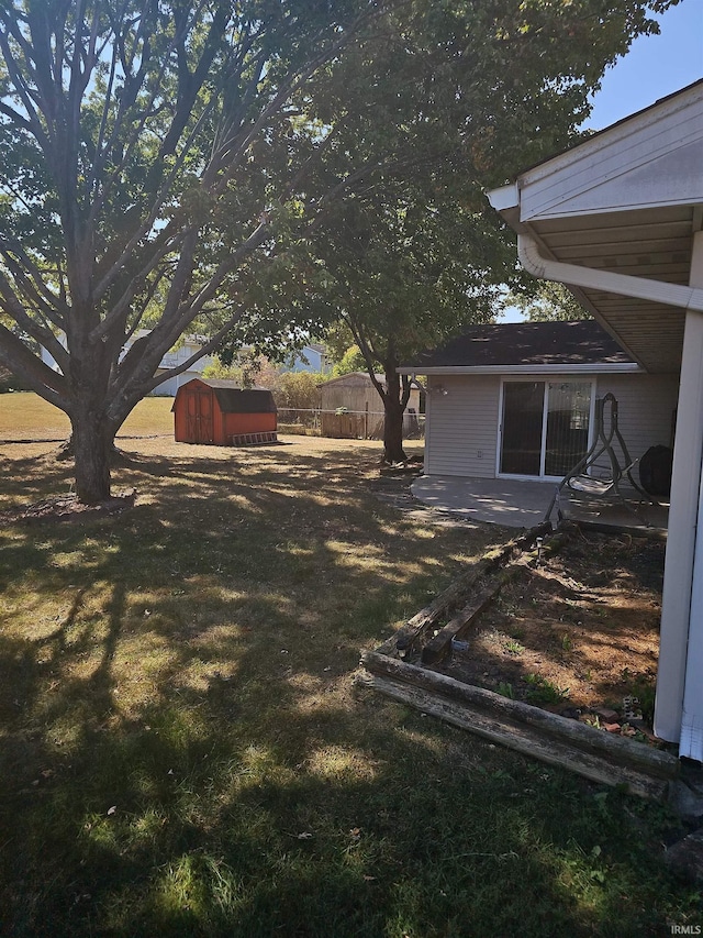 view of yard with a storage unit and a patio area