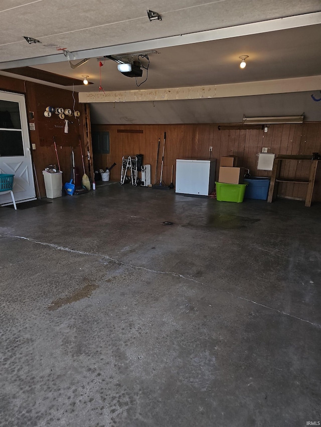 garage featuring a garage door opener and wood walls