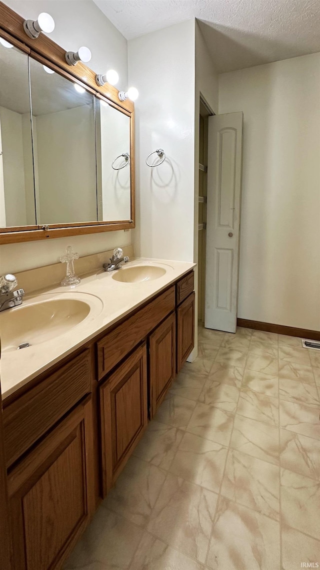 bathroom with a textured ceiling and vanity