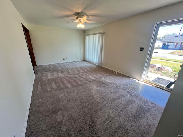 unfurnished room with ceiling fan and carpet