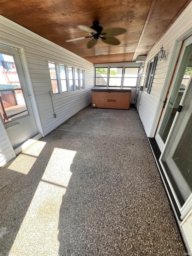 unfurnished sunroom with wood ceiling and ceiling fan