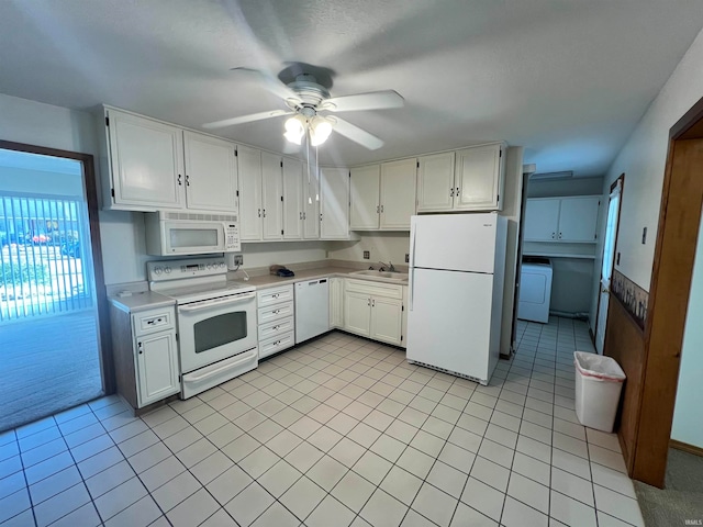 kitchen with white appliances, washer / dryer, sink, ceiling fan, and white cabinets