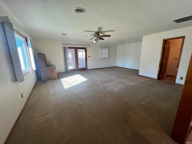 carpeted spare room featuring ceiling fan and a textured ceiling